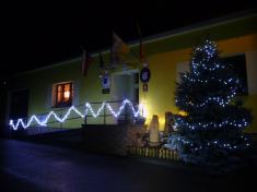 Betlém u&nbsp;vánočního stromečku a&nbsp;budova úřadu v&nbsp;noci